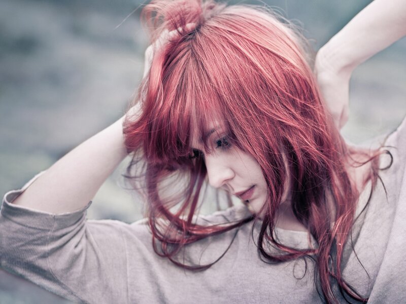woman with red hair looking down