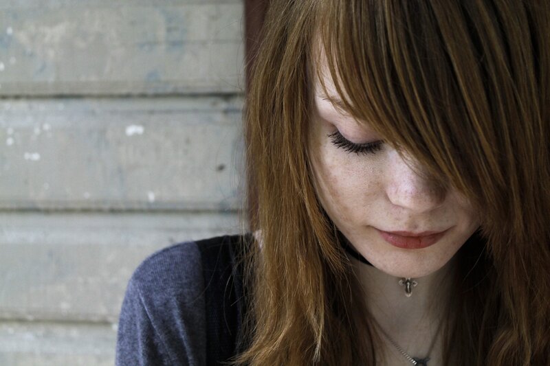 woman with red hair looking down