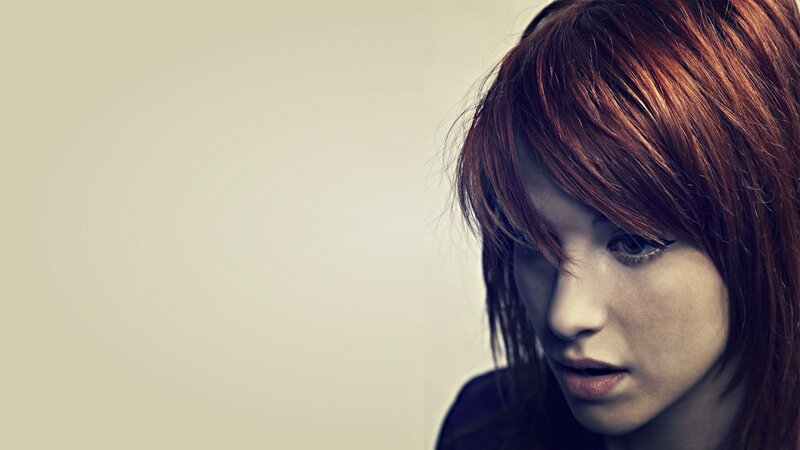 woman with red hair looking down