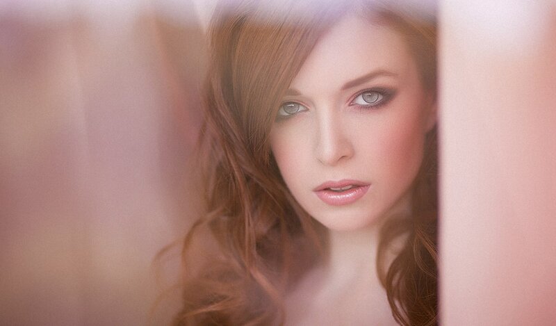 woman with red hair looking through a gap