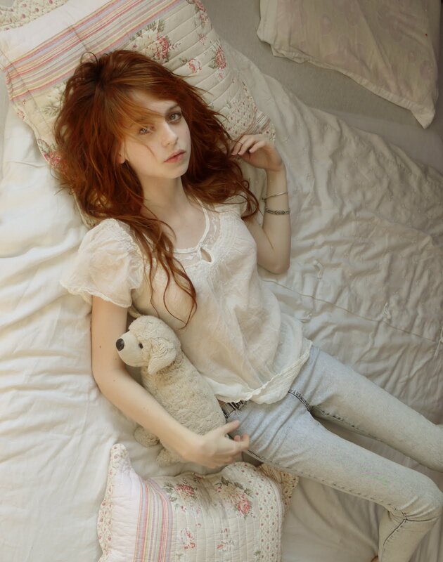woman with red hair lying in bed