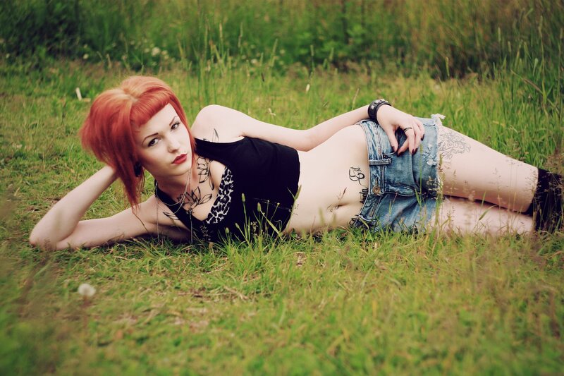 woman with red hair lying in grass