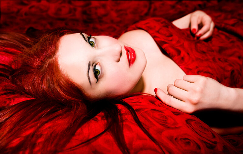 woman with red hair lying on bed