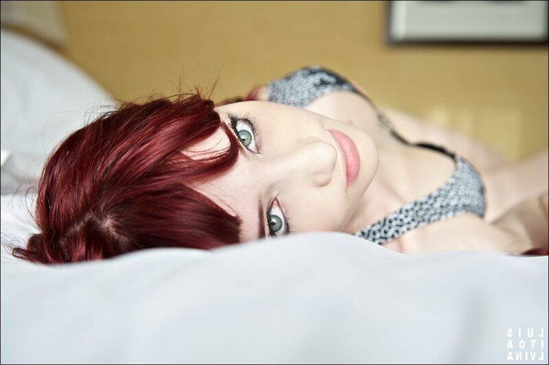 woman with red hair lying on bed