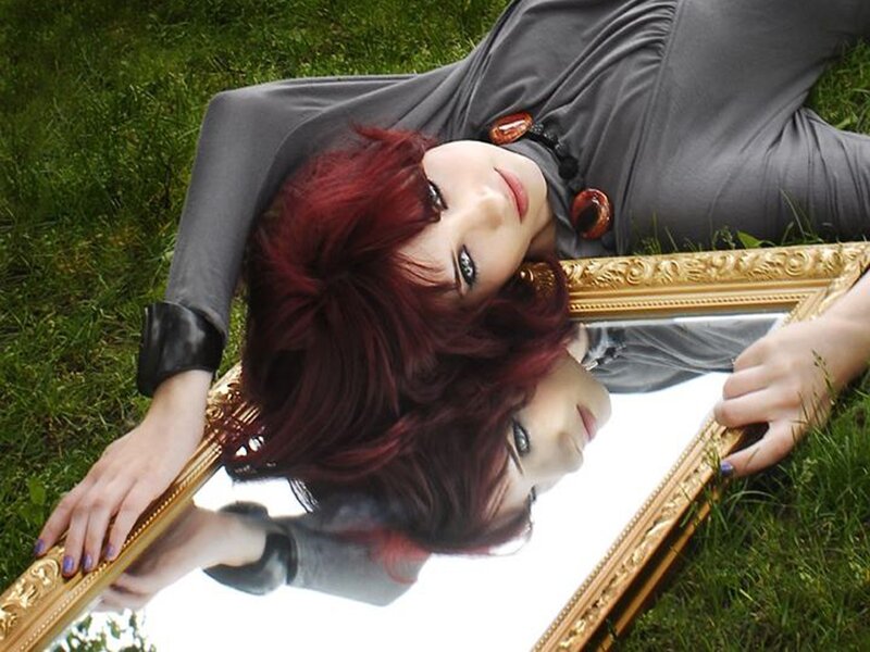 Woman with red hair lying on grass