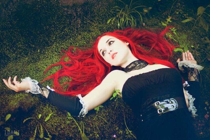 woman with red hair lying on moss