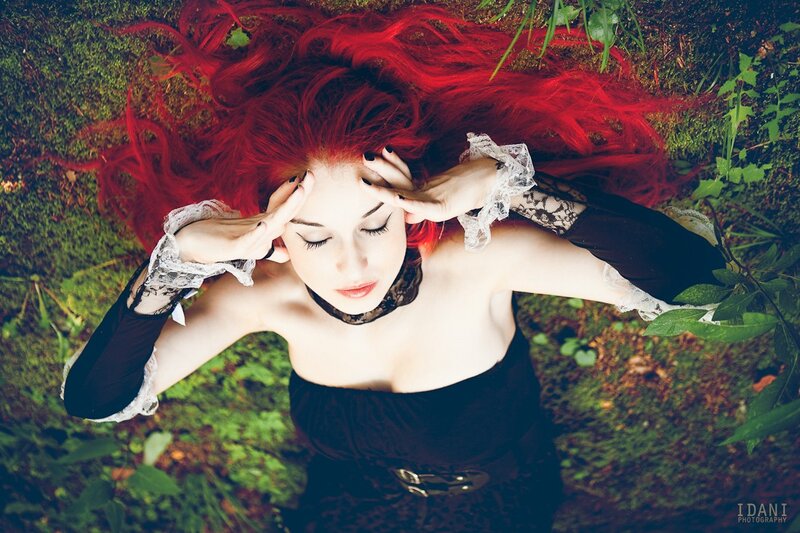 woman with red hair lying on moss