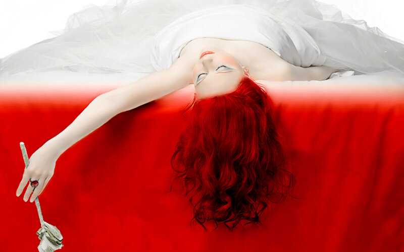 woman with red hair lying on red surface