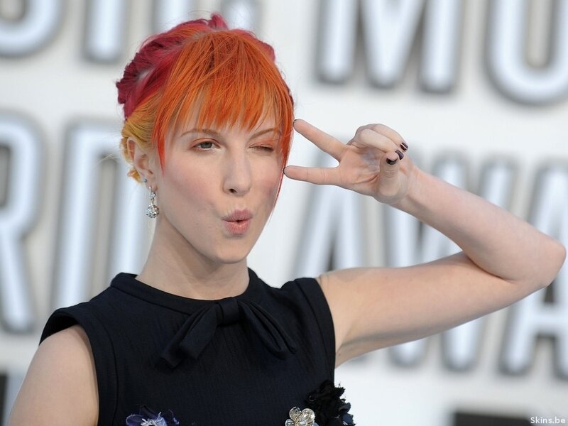 woman with red hair making peace sign