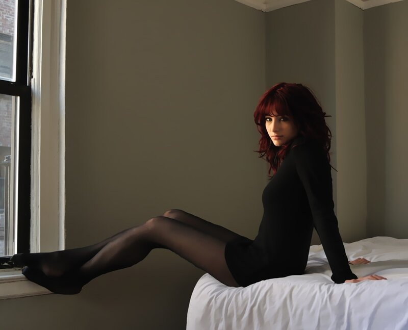 Woman with red hair on bed