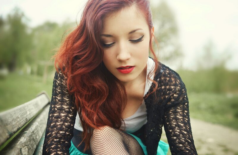 woman with red hair on bench
