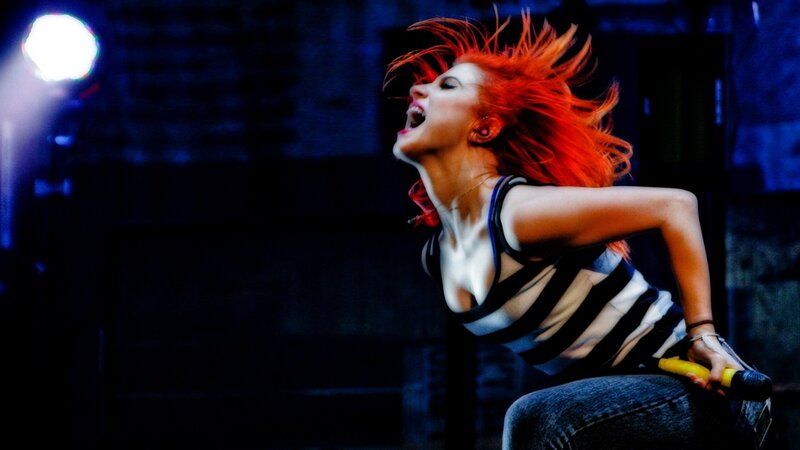Woman with Red Hair Singing — Dramatic, Night, Photograph, Microphone, Stage Light, Jeans