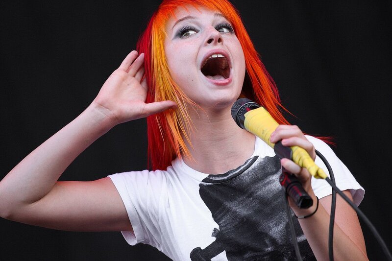 Woman with Red Hair Singing — Energetic, Photograph, Microphone, T-shirt, Black Background