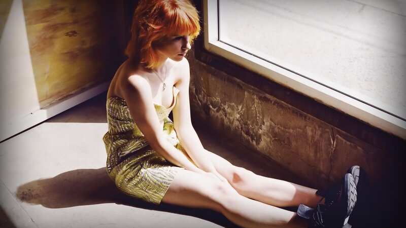 woman with red hair sitting by window