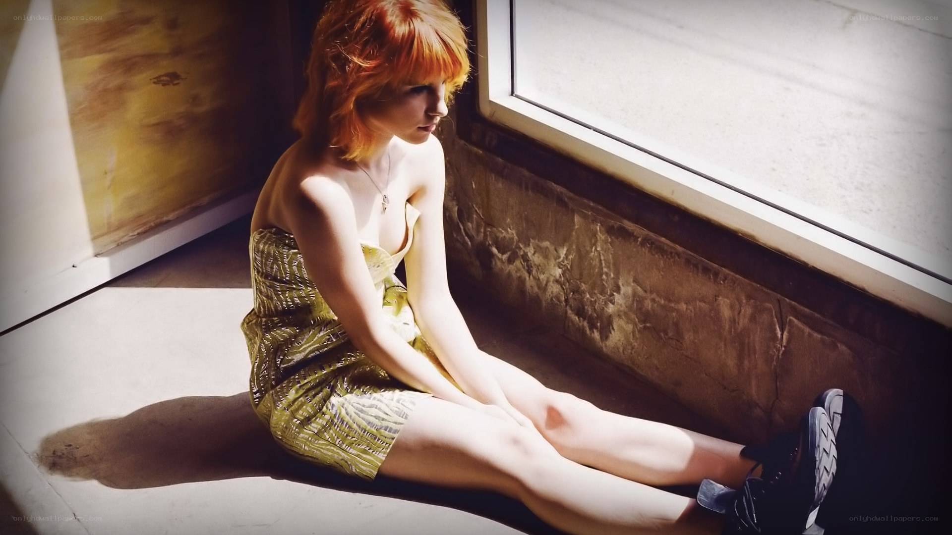 woman with red hair sitting by window