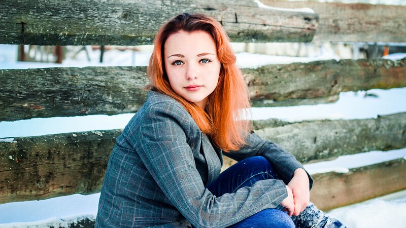 woman with red hair sitting on a bench