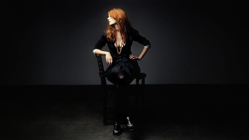 woman with red hair sitting on chair