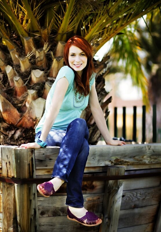 Woman with red hair sitting on wood