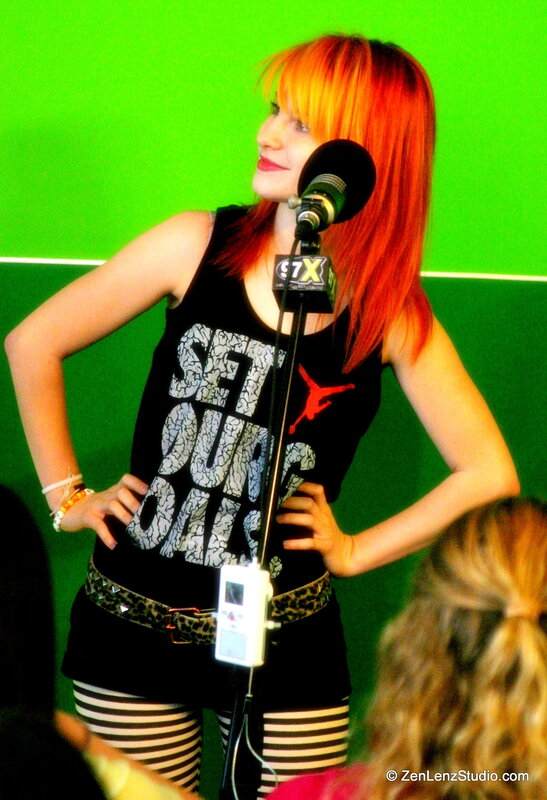 woman with red hair speaking into microphone