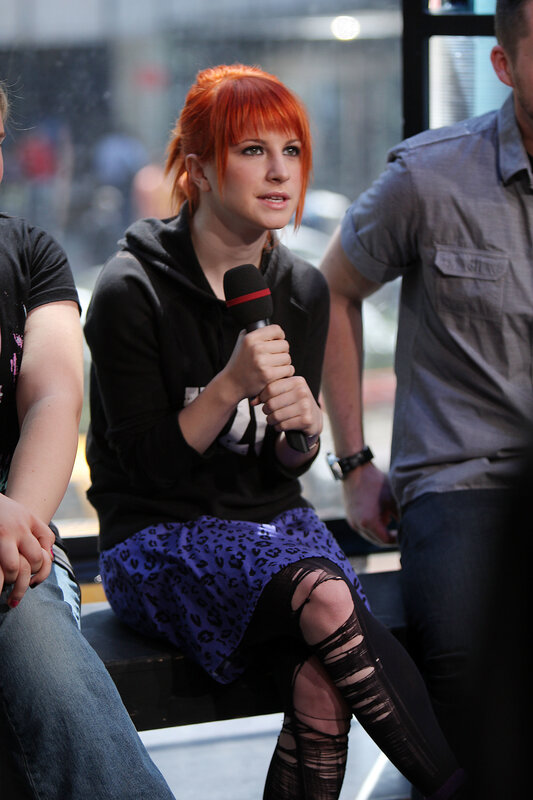 woman with red hair speaking into microphone