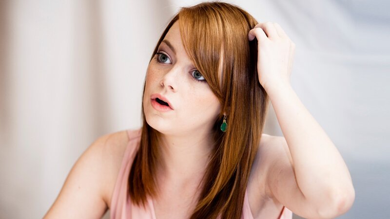 woman with red hair touching her head