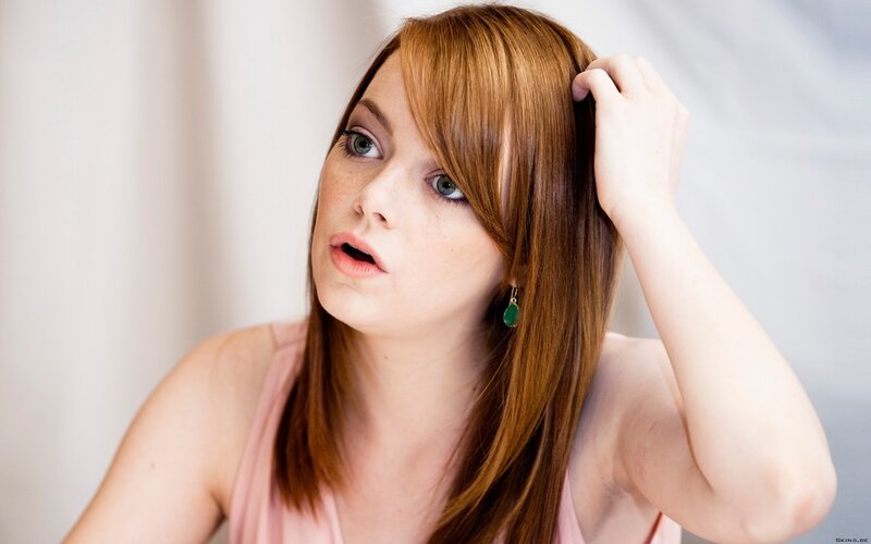 woman with red hair touching her head
