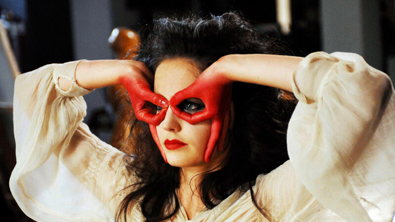 woman with red hands covering eyes