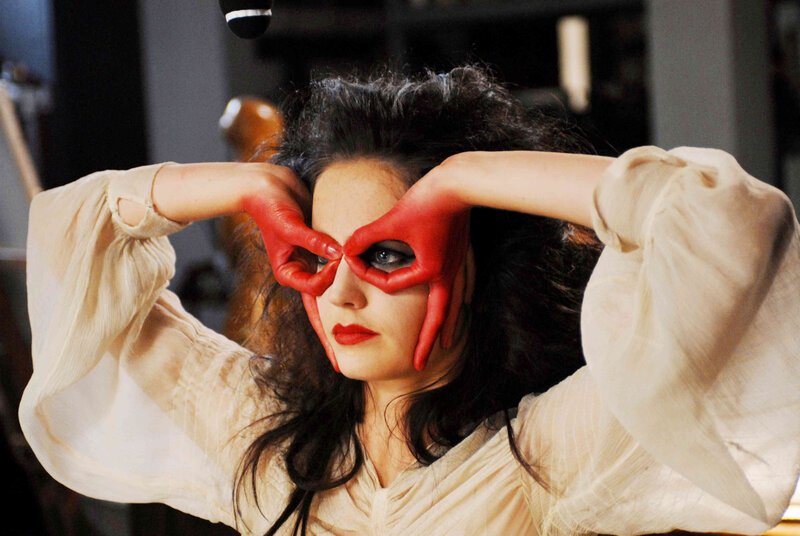 woman with red hands framing eyes