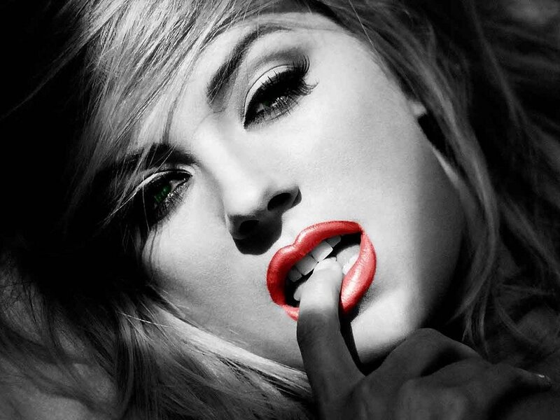 woman with red lips biting finger