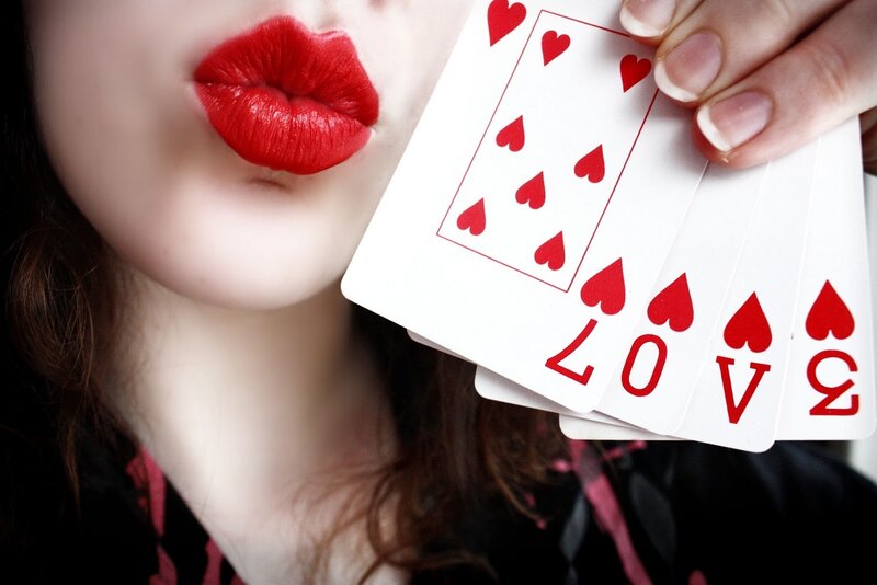 woman with red lips holding cards