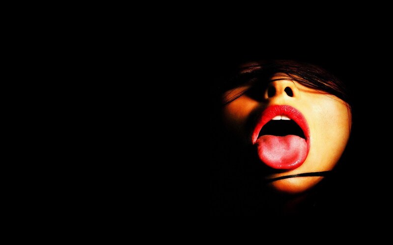 woman with red lips in darkness
