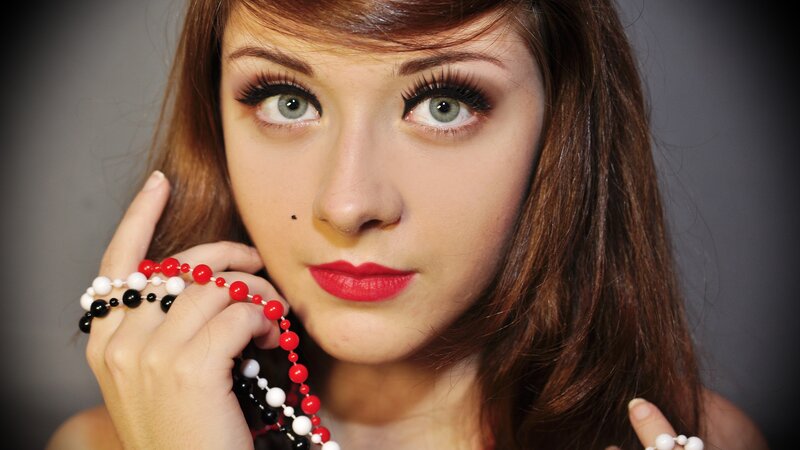 woman with red lipstick and beads