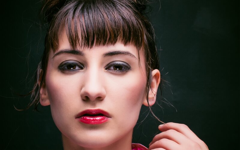 woman with red lipstick and dark makeup