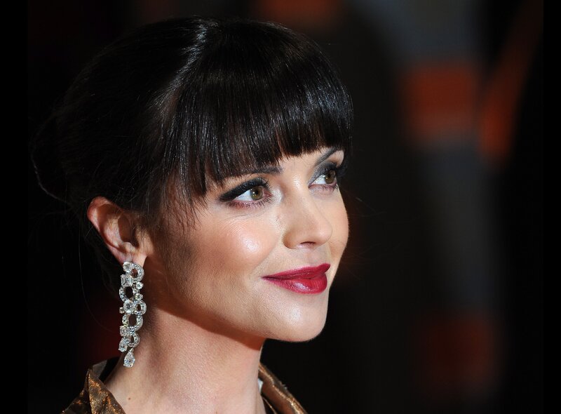 woman with red lipstick and earrings