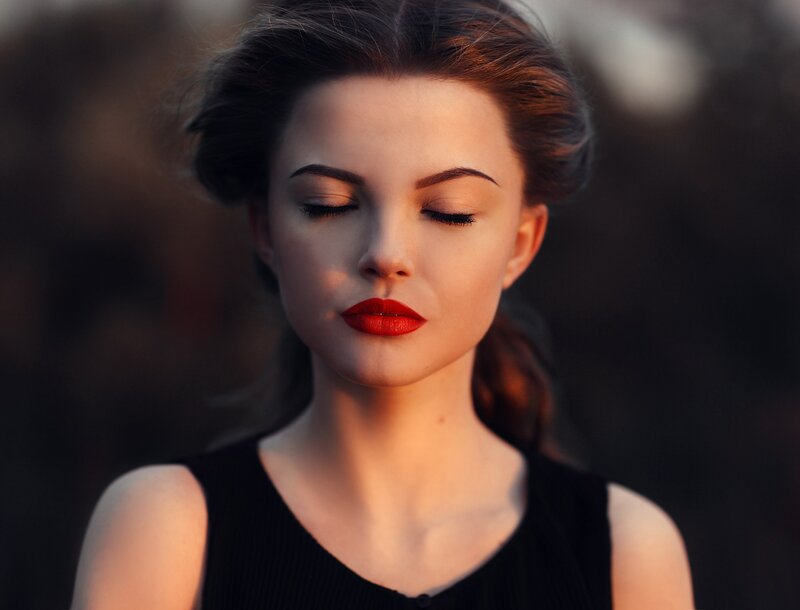 woman with red lipstick closing eyes