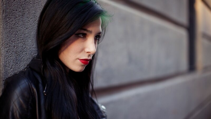 woman with red lipstick leaning against wall
