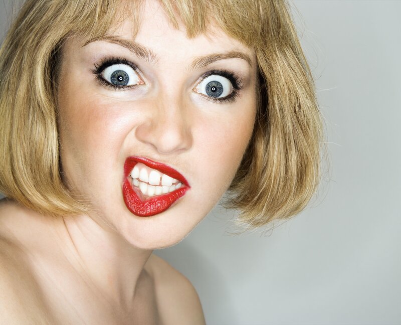 woman with red lipstick making face