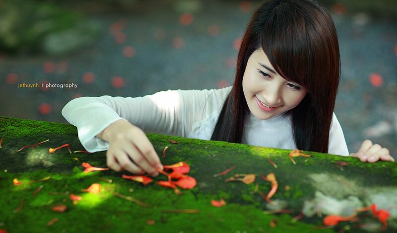 woman with red petals on moss