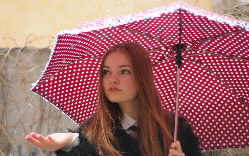 woman with red polka dot umbrella