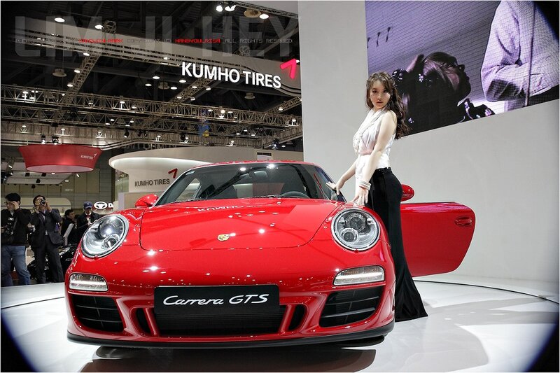 Woman with red Porsche at auto show