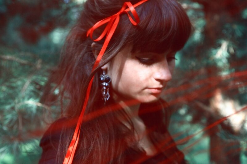 woman with red ribbon in forest