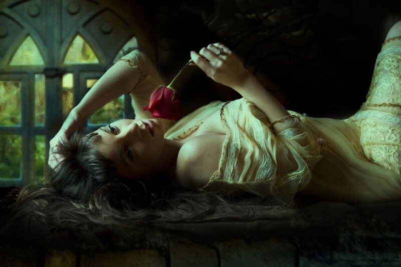woman with red rose in gothic room