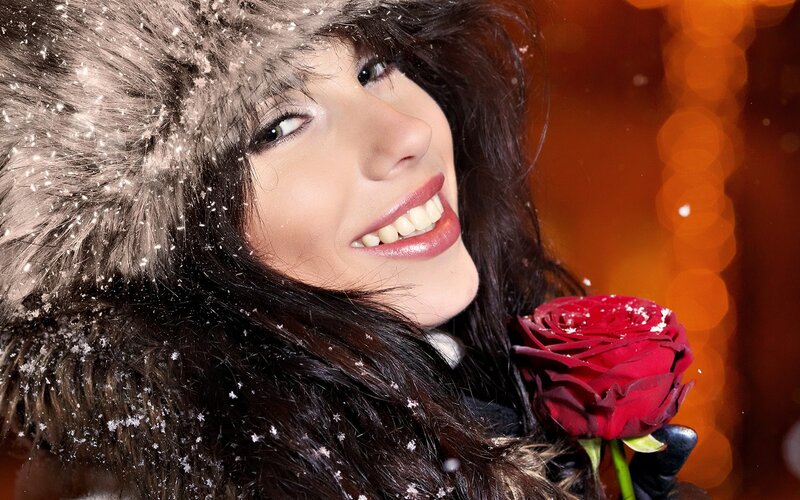 woman with red rose in snow