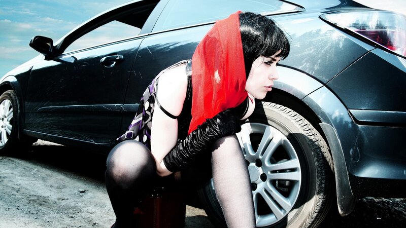 woman with red scarf by car