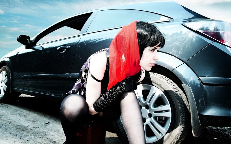 woman with red scarf by car
