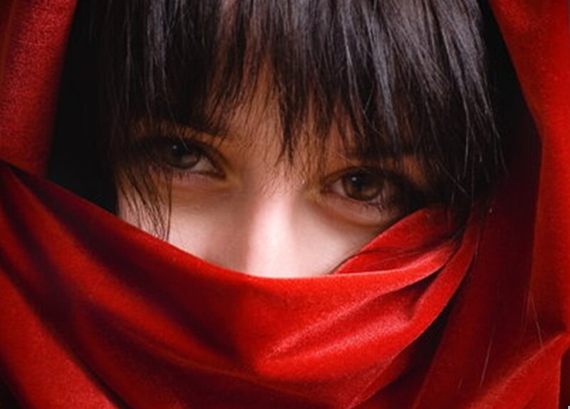 woman with red scarf covering face