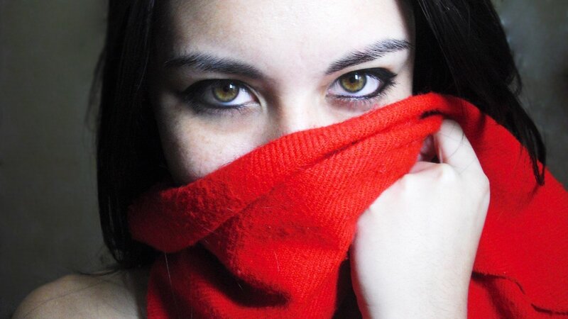 woman with red scarf covering face