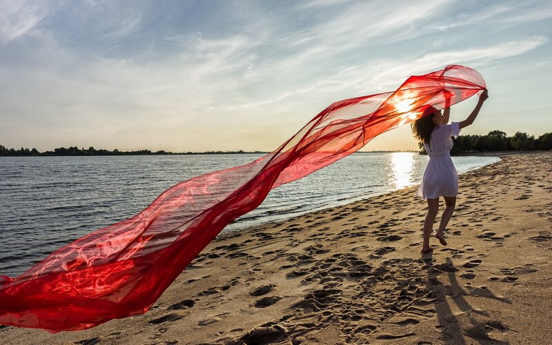Woman with red scarf on beach