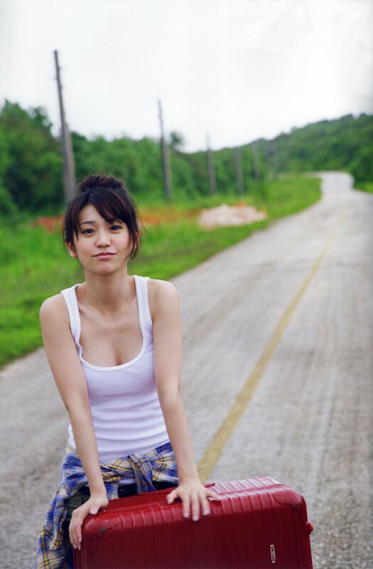 Woman with red suitcase on road
