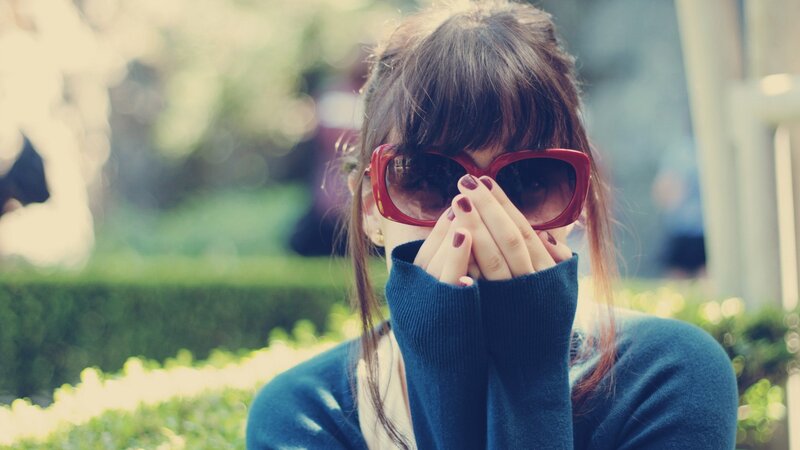 woman with red sunglasses covering face